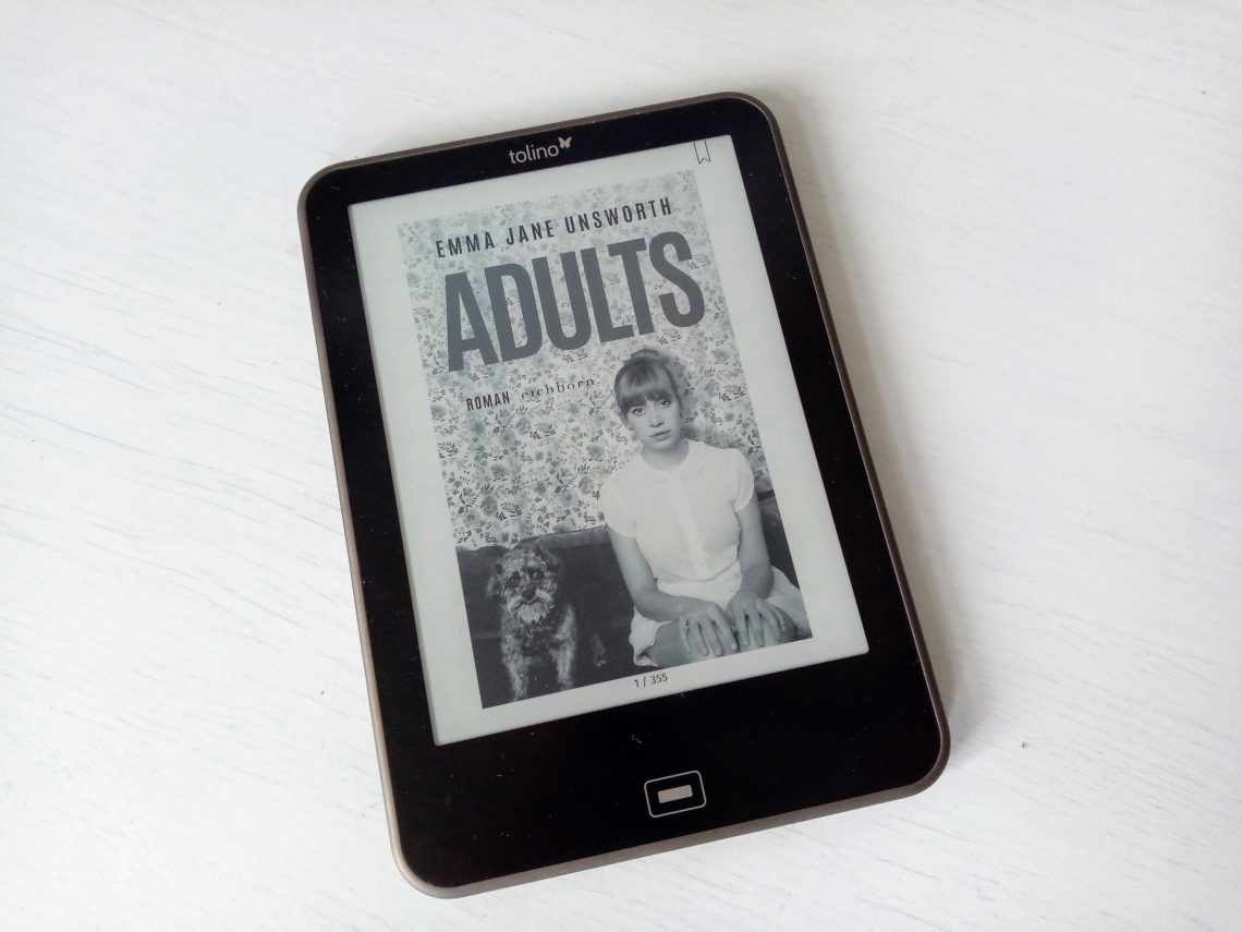 Ein Reader zeigt das Cover von "Adults" mit einer unglücklichen jungen Frau neben einem Hund vor einer Tapete